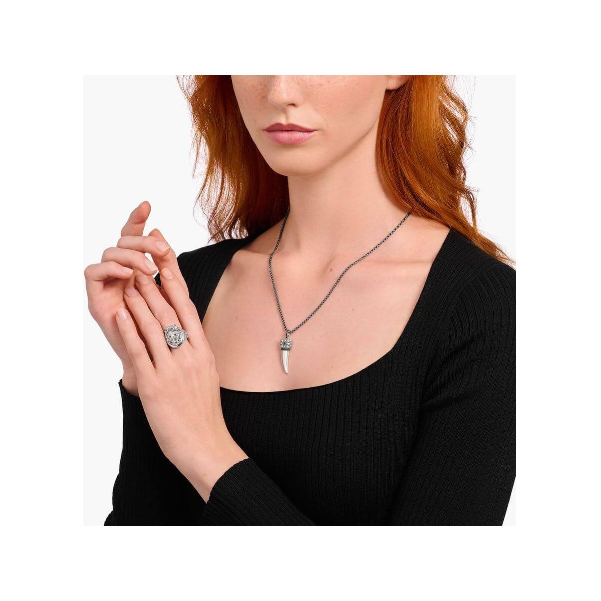 Modèle portant une chaîne à breloque dent ornée de gemmes en argent noirci avec un élégant design.