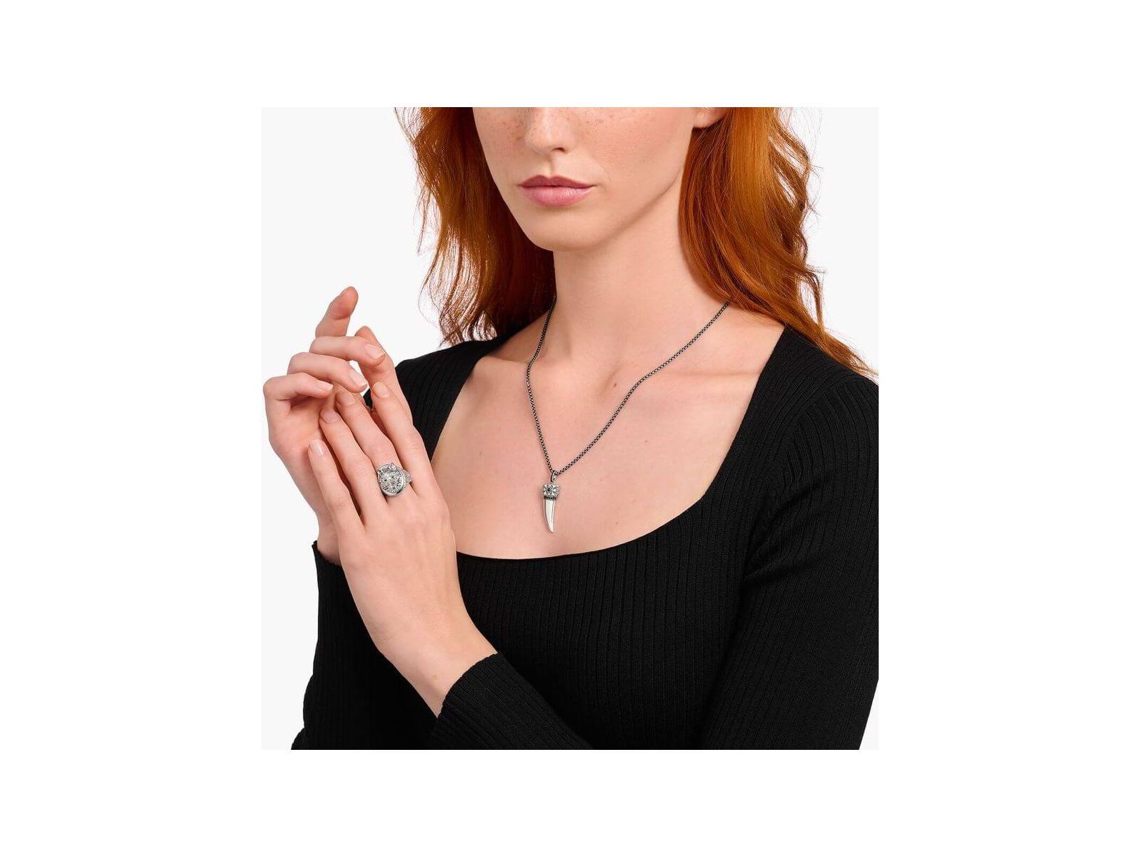 Modèle portant une chaîne à breloque dent ornée de gemmes en argent noirci avec un élégant design.