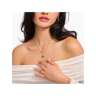 Femme portant une chaîne avec pendentif cœur en argent et or, mettant en valeur le style vintage et élégant.