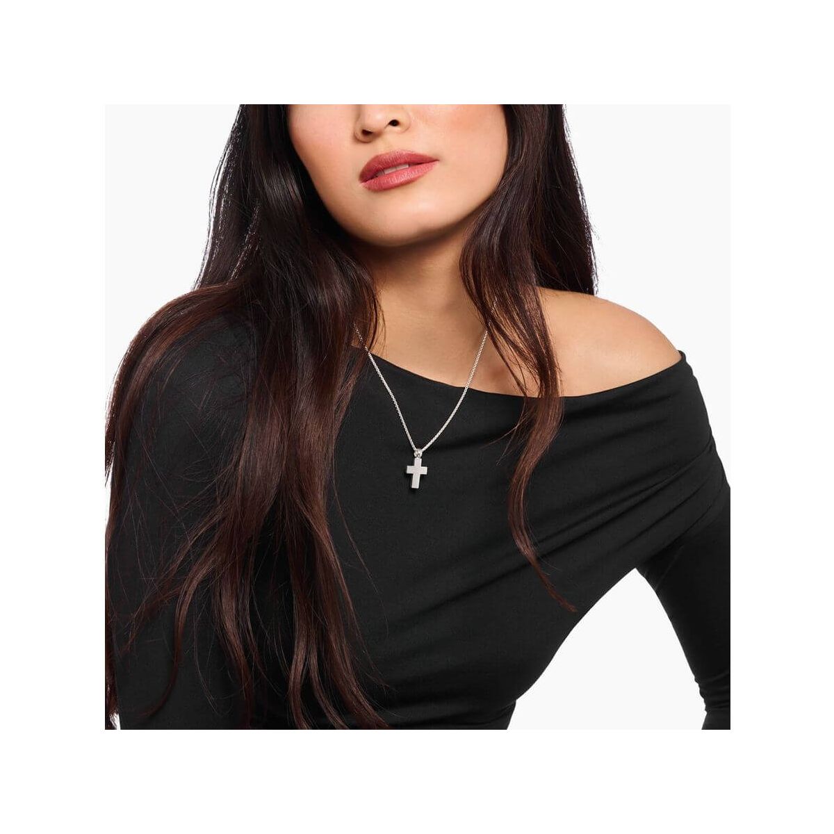 Woman wearing a handmade silver cross pendant on a delicate chain, showcasing classic minimalist style.