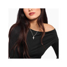 Woman wearing a handmade silver cross pendant on a delicate chain, showcasing classic minimalist style.