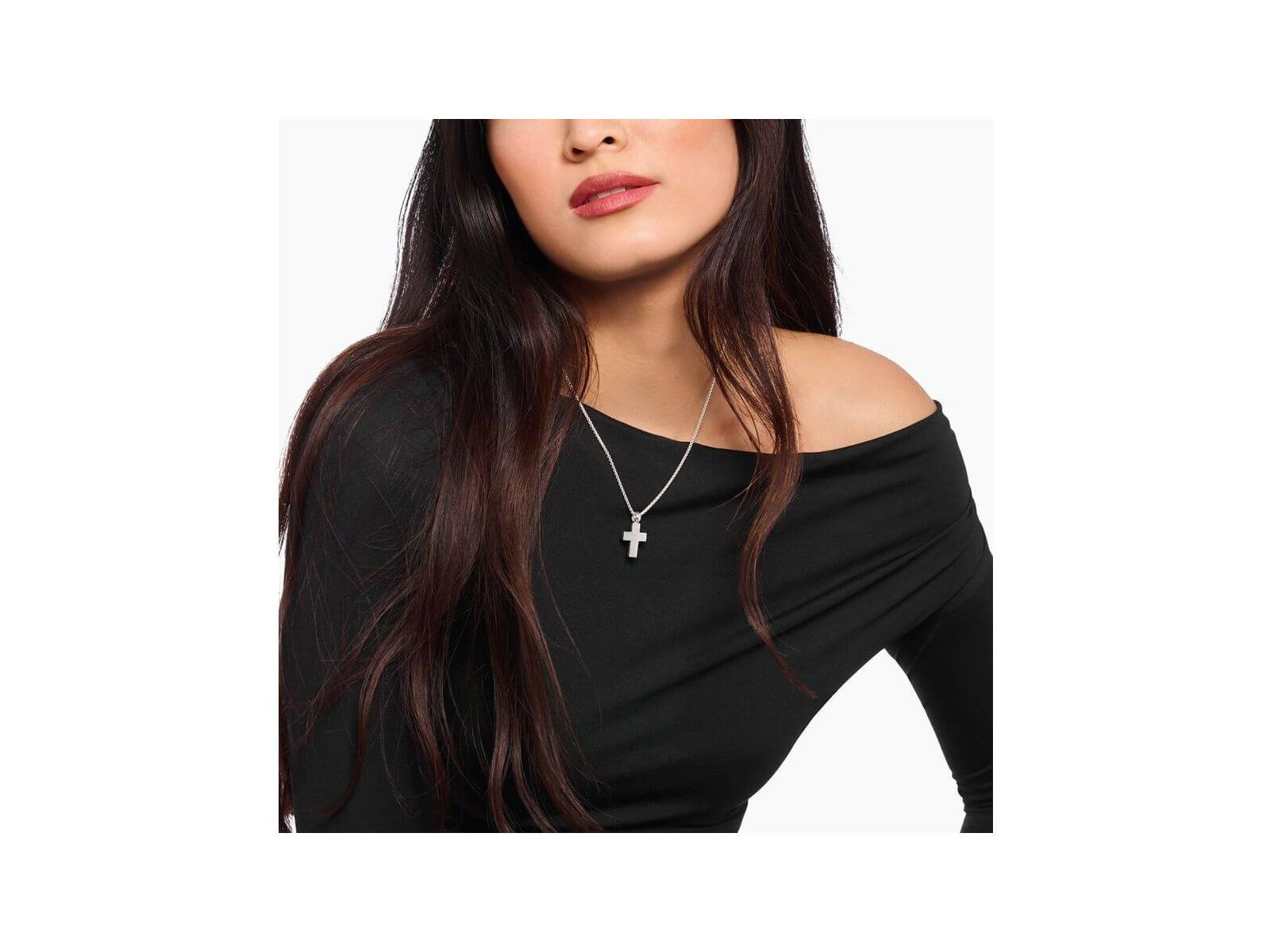 Woman wearing a handmade silver cross pendant on a delicate chain, showcasing classic minimalist style.