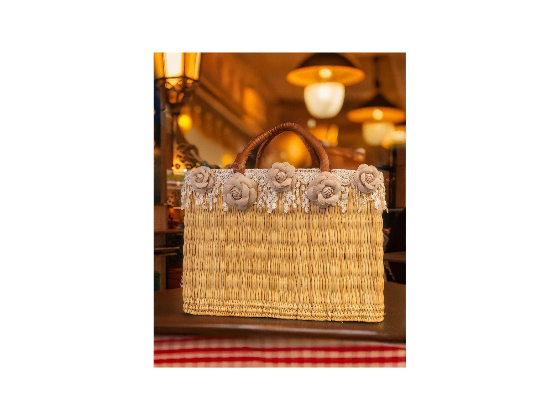 Panier en osier décoré de fleurs colorées et franges, idéal pour un look estival élégant et tendance.