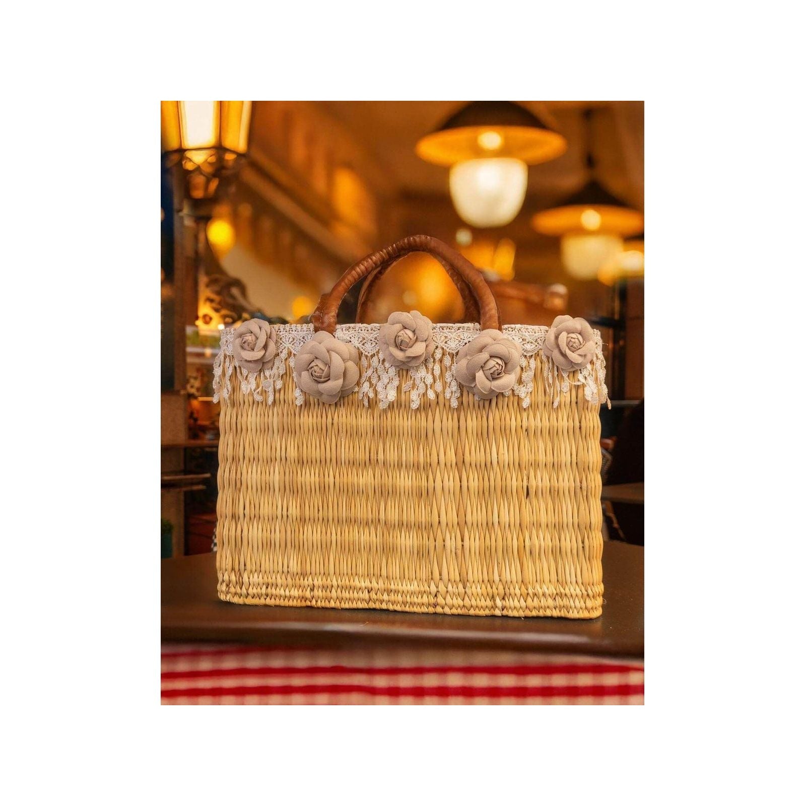 Panier en osier décoré de fleurs colorées et franges, idéal pour un look estival élégant et tendance.