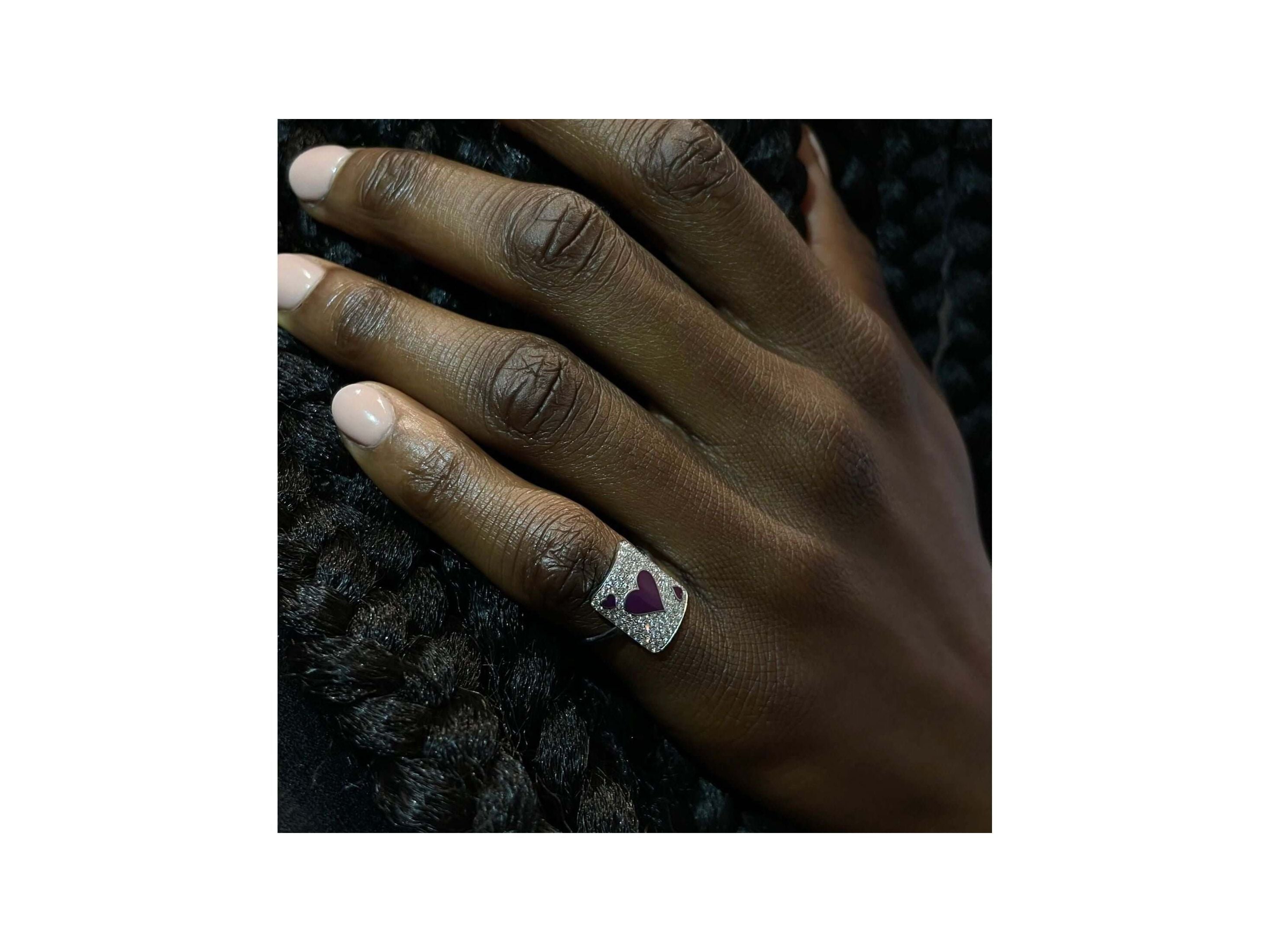 Hand wearing the Bague Pinkie Lovely Âme ring featuring a heart design, showcasing its elegant craftsmanship.