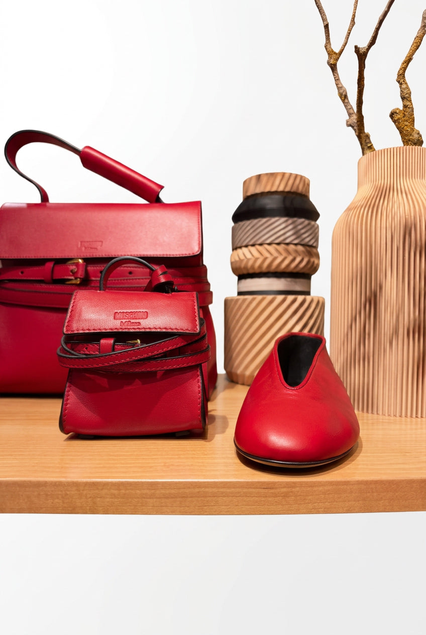 Sac à main Moschino cuir 10x10 cm rouge avec chaussures assorties sur étagère en bois.