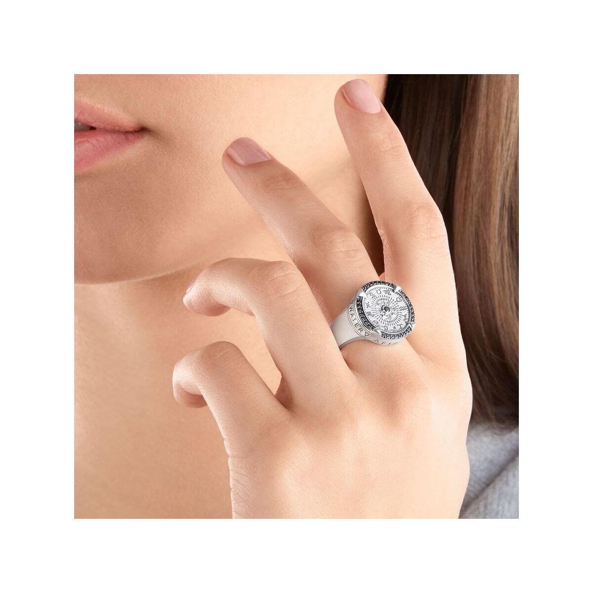 Woman wearing Bague Elements of Nature sterling silver ring featuring zodiac signs and engraved elements.
