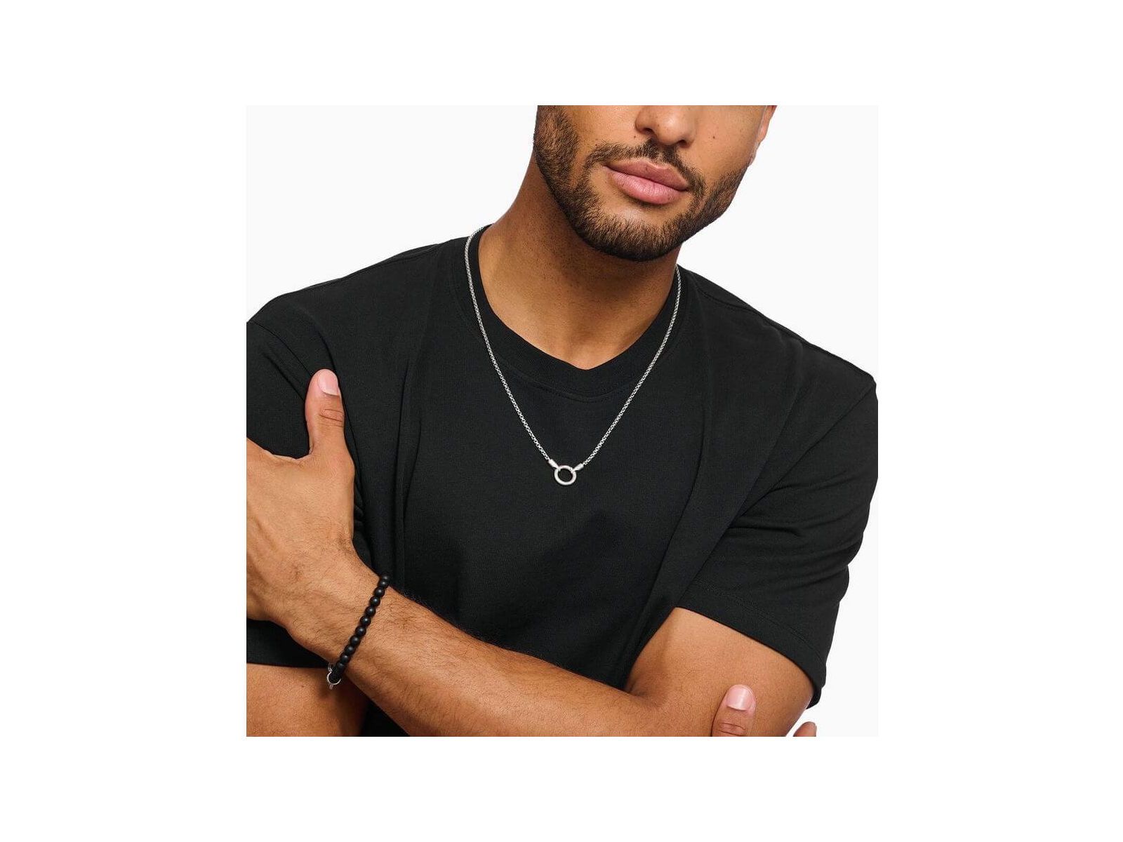 Homme portant un collier vénitien en argent avec fermoir rond, style minimaliste sur t-shirt noir.