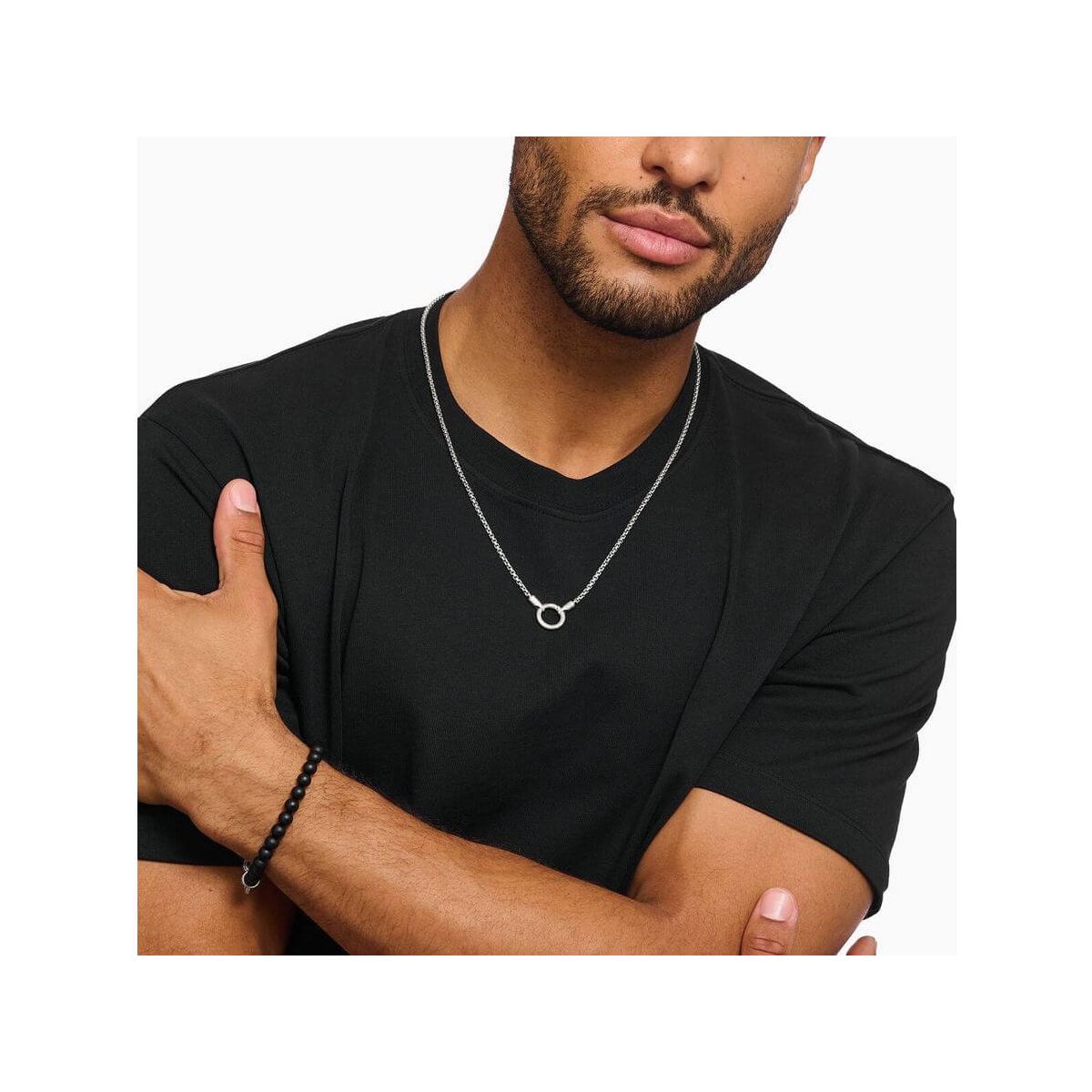 Homme portant un collier vénitien en argent avec fermoir rond, style minimaliste sur t-shirt noir.