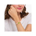 Bracelet de perles d'eau douce avec ours d'or vert sur le poignet d'une femme, style unique et original.