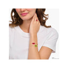 Femme portant un bracelet fantaisie avec ours d'or vert et perles, évoquant l'élégance et la nostalgie.