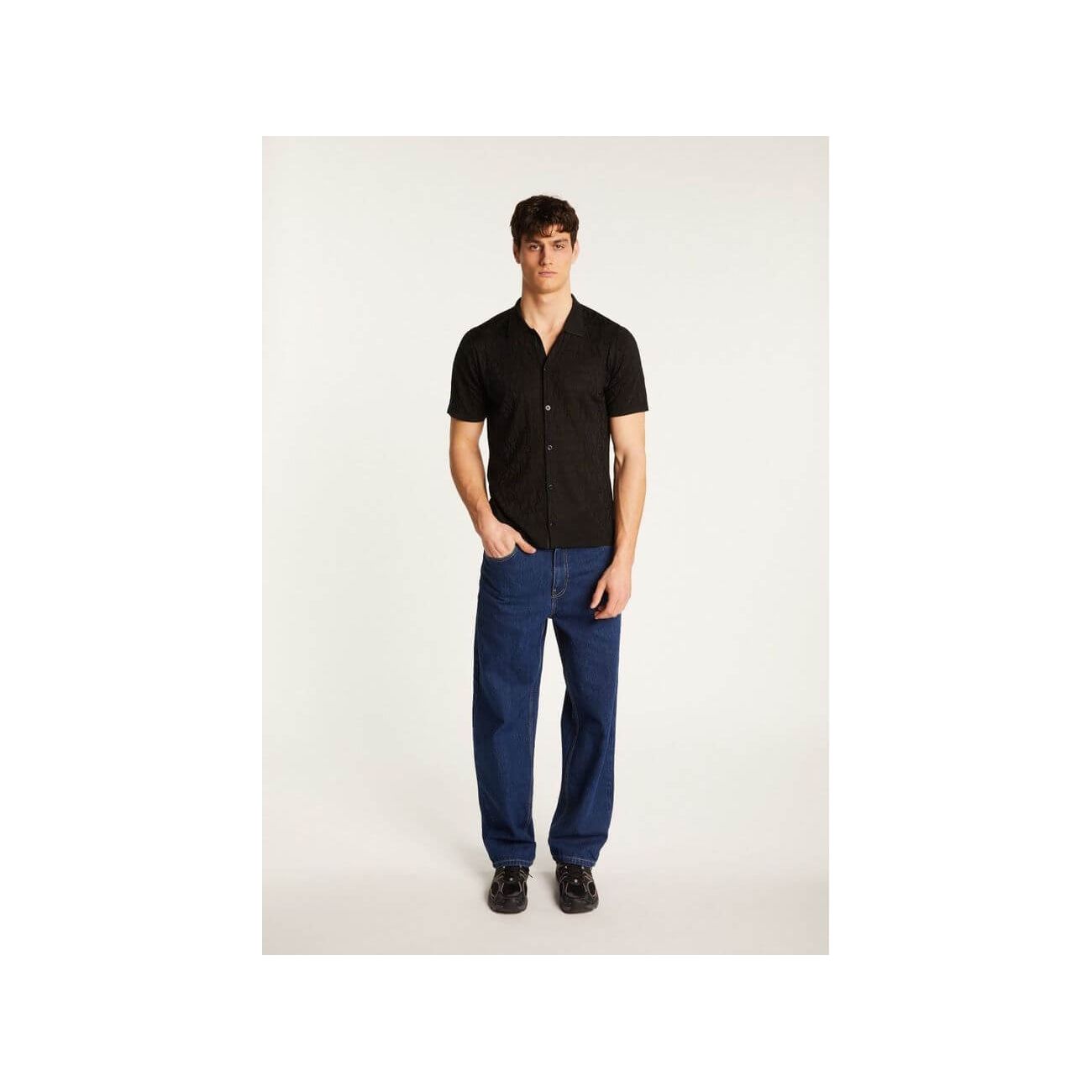 Homme portant une chemise Matthew en polyamide, avec un look moderne et élégant, accompagné de pantalons bleu.