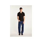 Homme portant une chemise Matthew en polyamide, avec un look moderne et élégant, accompagné de pantalons bleu.