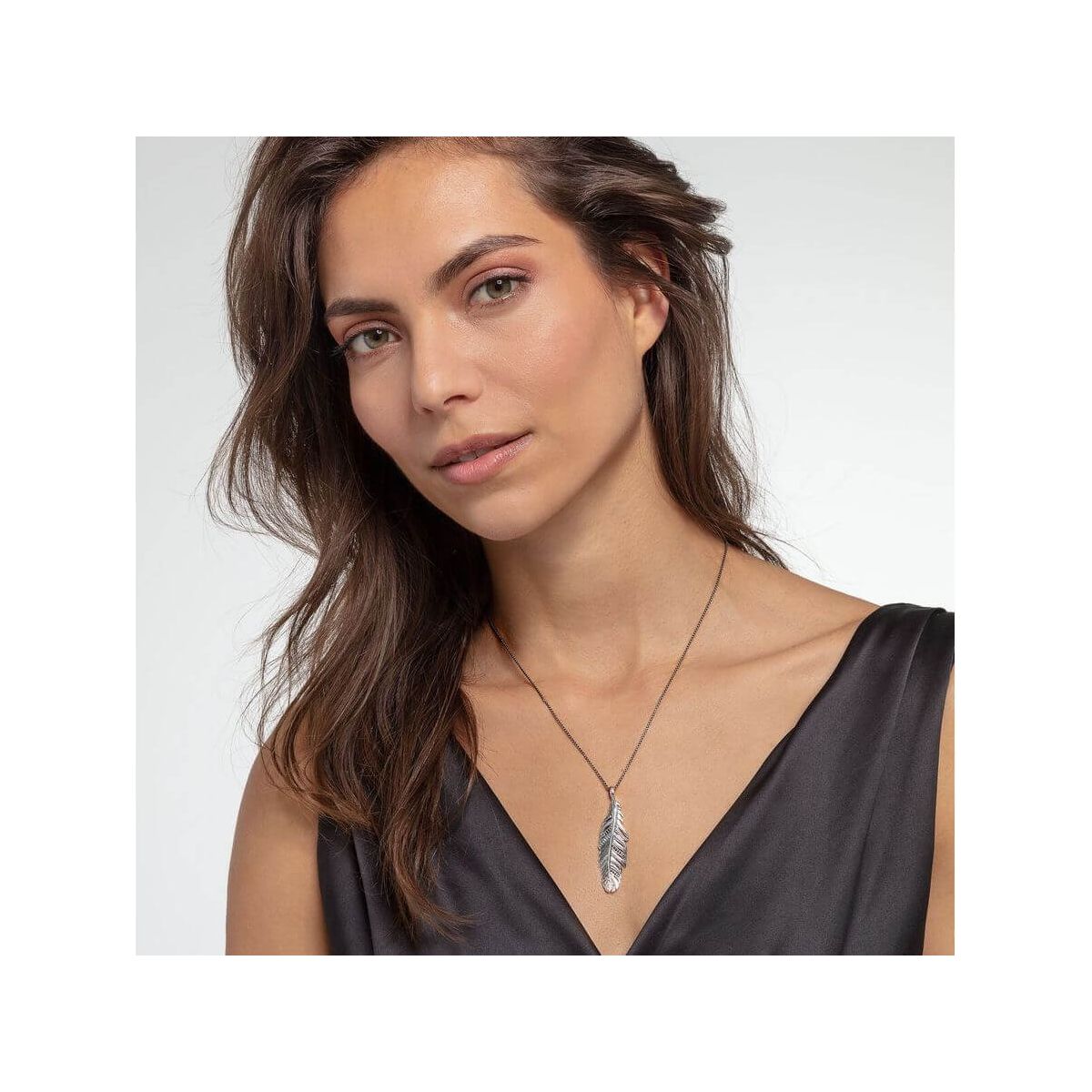 Femme portant le pendentif plume en argent sterling noirci de THOMAS SABO, mettant en avant son élégance.