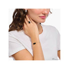 Woman wearing a stylish adjustable bracelet with a black satin crystal bear pendant and freshwater pearl.