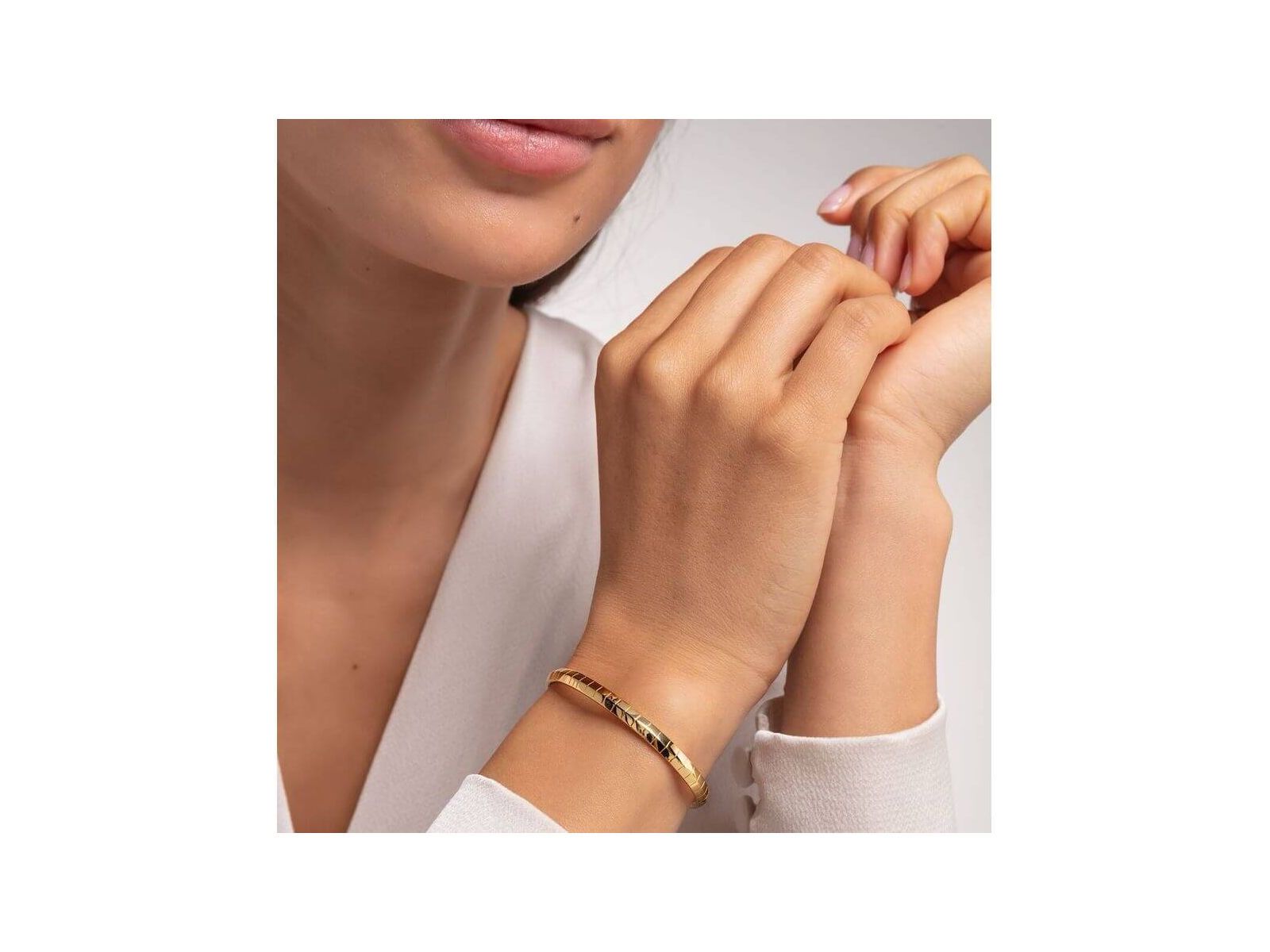 Bracelet jonc peau de serpent or porté par une femme, ajoutant une touche élégante et moderne à son style.