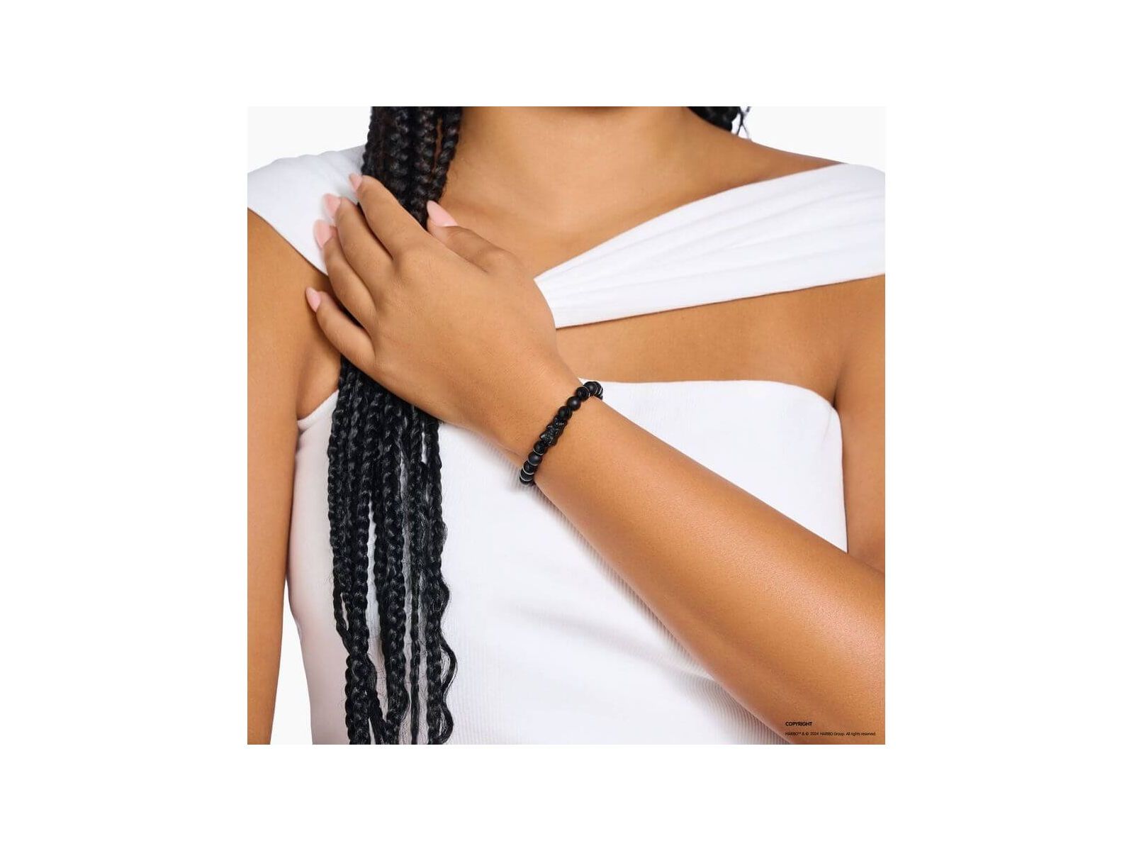 Bracelet en beads d'obsidienne noire avec ours en cristal noir, porté sur un poignet féminin.