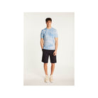 Model wearing a light blue tie-dye T-shirt paired with dark shorts and sneakers.