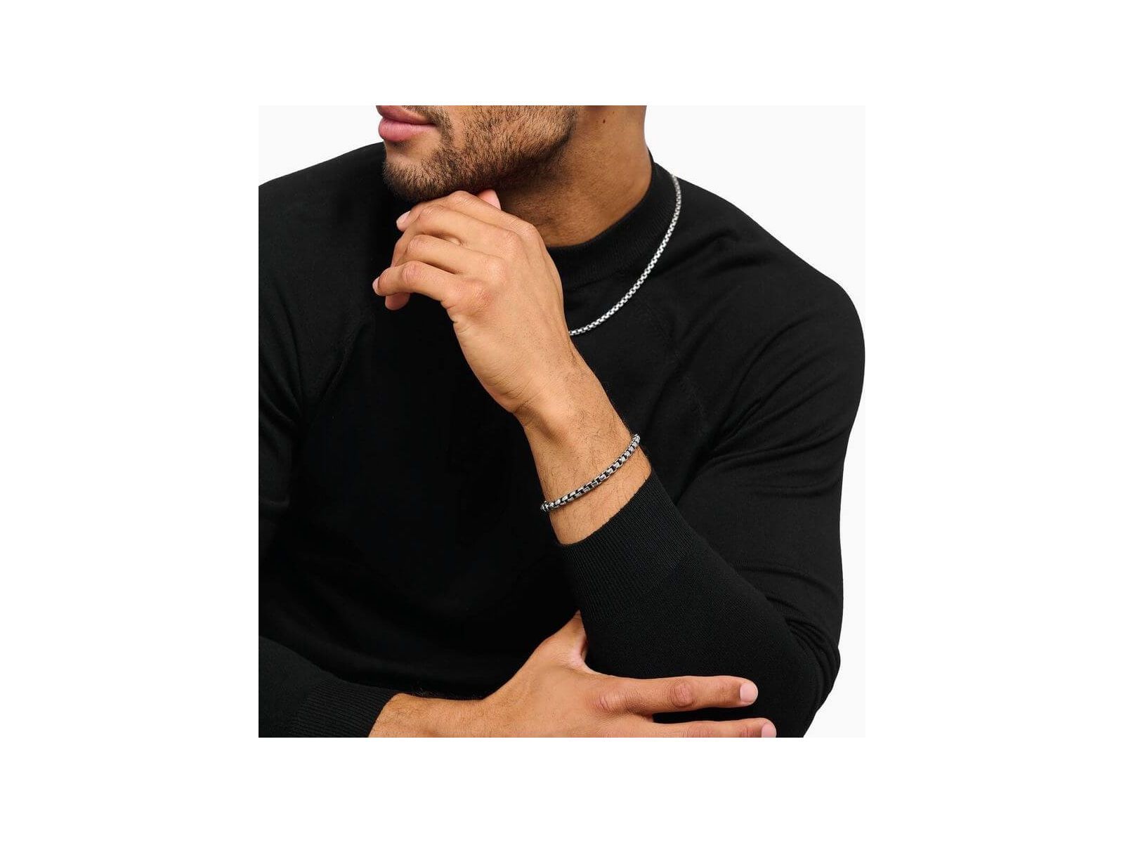 Homme portant un bracelet en argent box chain, avec un design élégant, associé à un t-shirt noir.