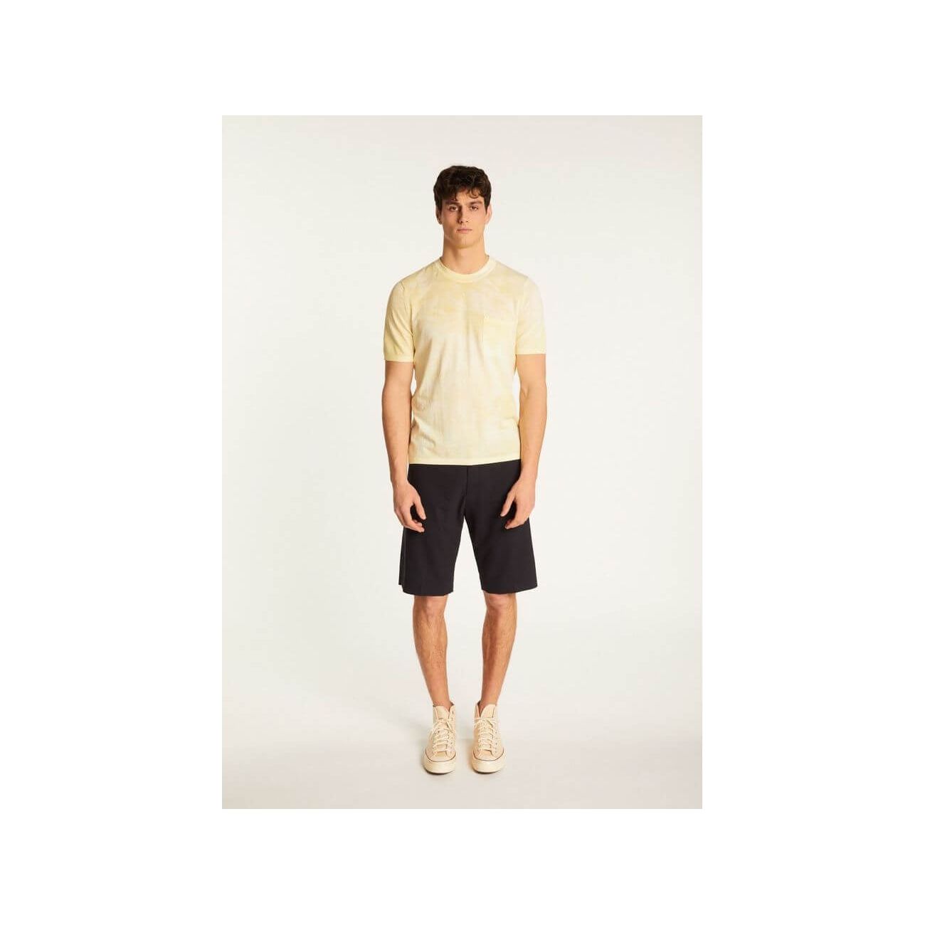 Model wearing a lightweight, breathable yellow T-Shirt Marquez with a discreet pocket, paired with dark shorts.
