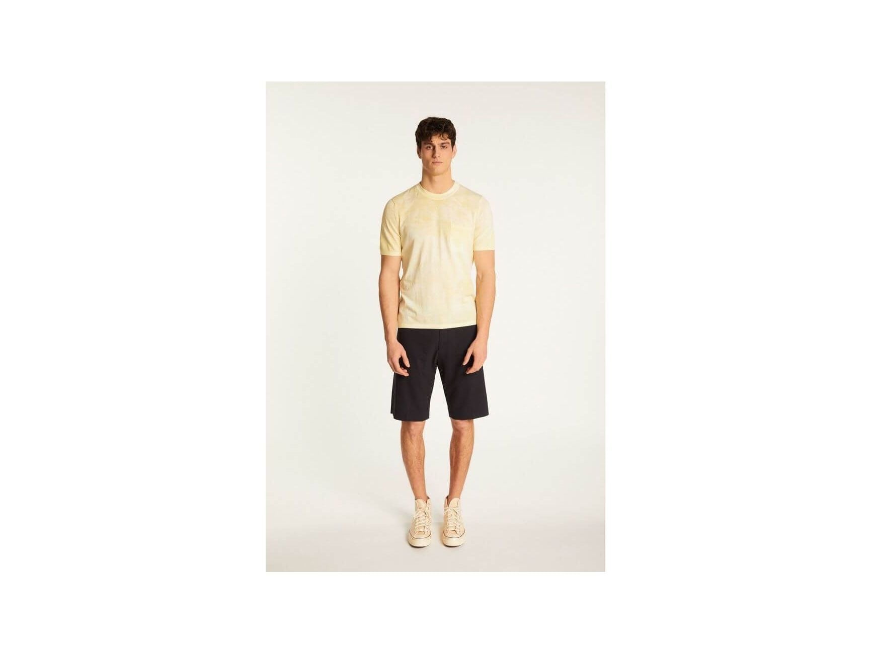 Model wearing a lightweight, breathable yellow T-Shirt Marquez with a discreet pocket, paired with dark shorts.
