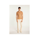 Homme portant un polo en Fil lumière Babar, couleur beige, avec pantalon clair et baskets.