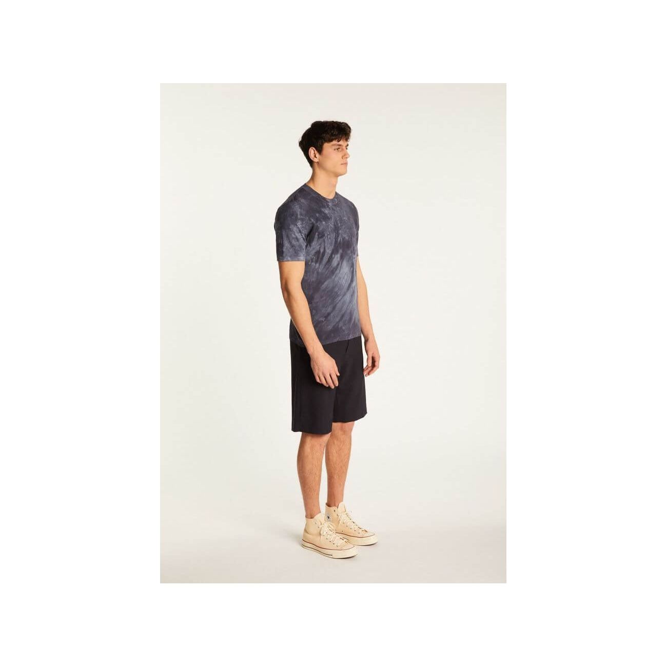 Model displaying the Marquez T-Shirt in a stylish tie-dye pattern, paired with shorts for a casual look.