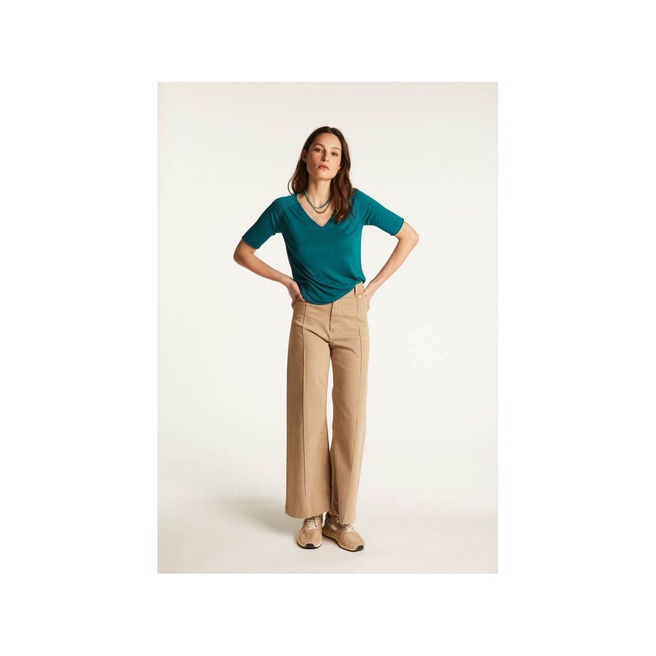 Modèle portant un T-shirt femme Bonbon en lin flammé, associé à un pantalon large beige, dans un style décontracté.