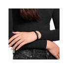Bracelet en obsidienne avec perle en forme de chat noir, porté sur un bras, style élégant et raffiné.