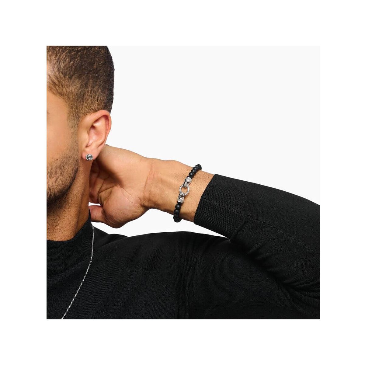 Homme portant un bracelet en beads d'obsidienne noire et argent, mettant en valeur l'élégance et la sophistication.