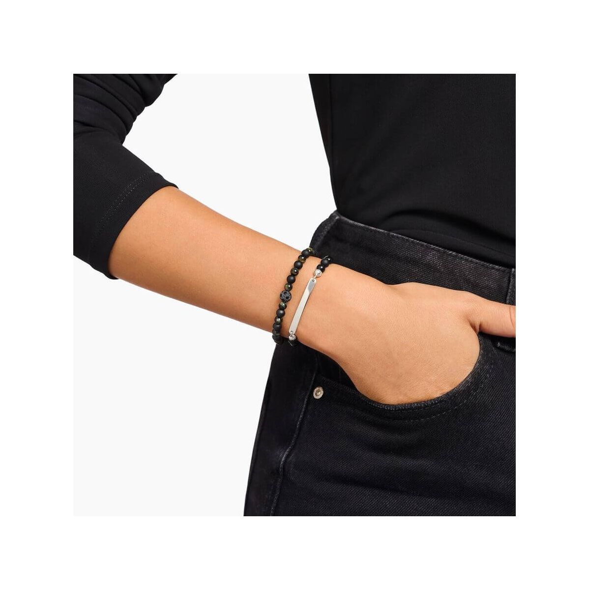 Bracelet à graver avec perles en obsidienne noire et barrette en argent, porté sur le poignet d'une personne.