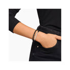 Bracelet à graver avec perles en obsidienne noire et barrette en argent, porté sur le poignet d'une personne.