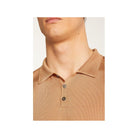 Close-up of a beige Polo fil lumière Babar shirt, showcasing its soft texture and button details.