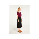 Model showcasing Larra T-shirt, a chic V-neck design in burgundy paired with a flowy black skirt, highlighted for elegance and comfort.