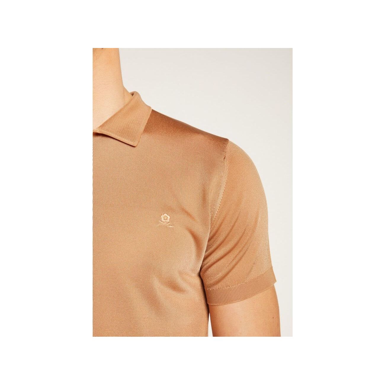 Close-up of a tan short-sleeve polo shirt made of Fil lumière fabric, showcasing its elegant texture.