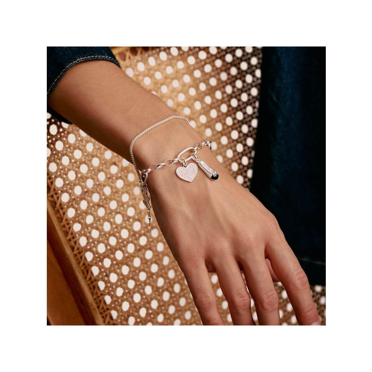 Bracelet charm en argent avec lien connect, cœur et breloque, élégant et personnalisable, porté sur un poignet.