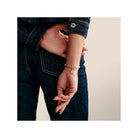 Bracelet with star charm and white stone, showcasing elegance and style on a woman's wrist.