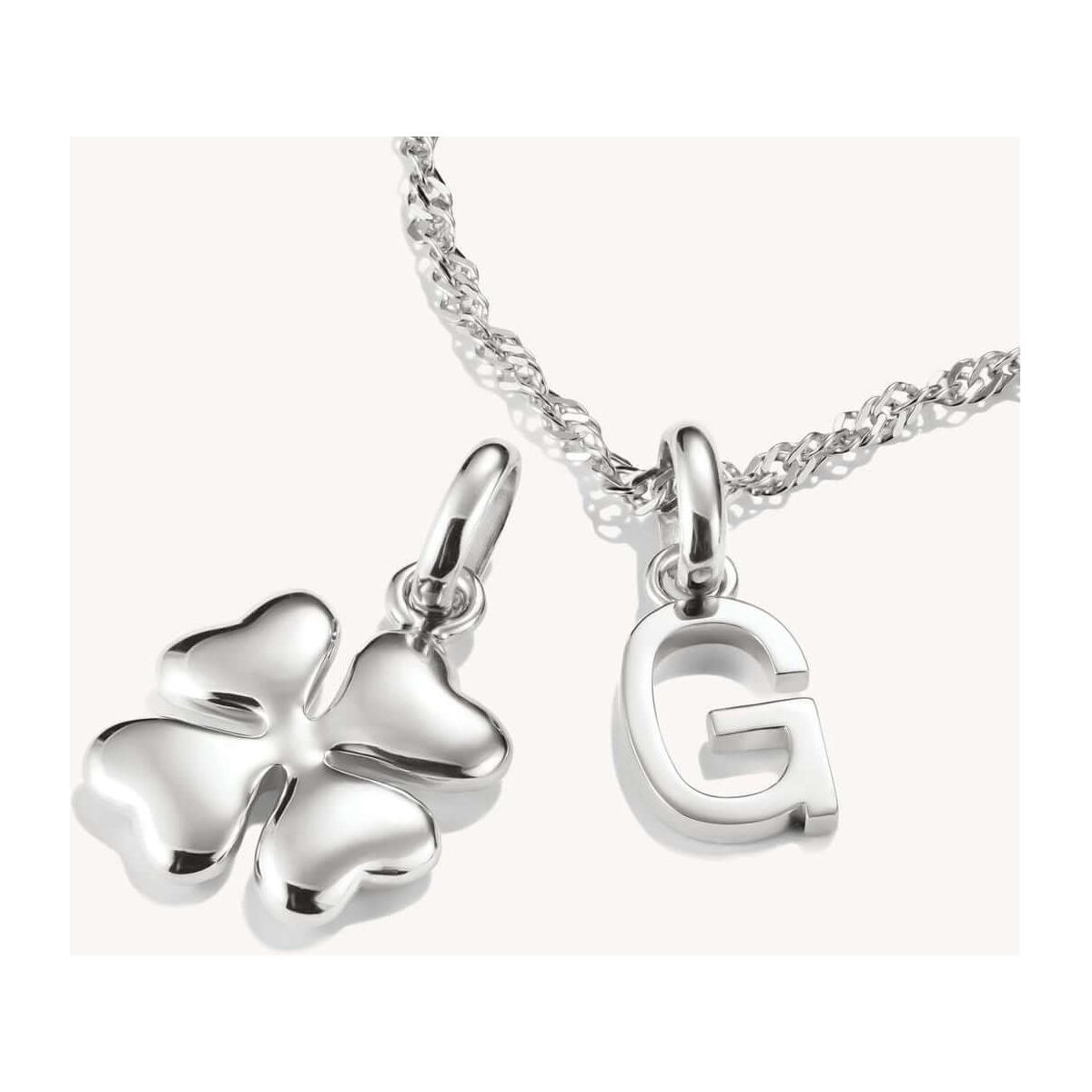 Pendentif charm en argent 925 en forme de trèfle à quatre feuilles et lettre G sur chaîne, symbole de chance.