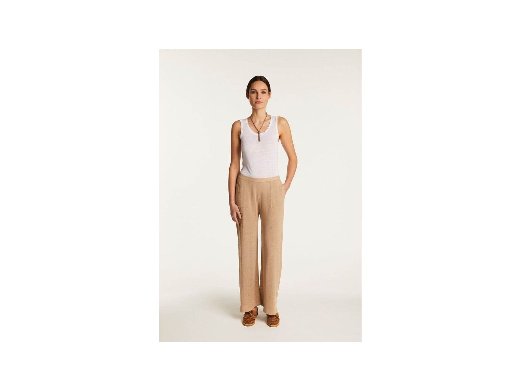 Debora linen flammé pants featuring a relaxed fit, paired with a white tank top for a casual yet elegant look.