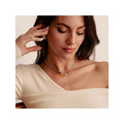 Femme portant un pendentif charm fleur de rose en argent sur un collier, affichant un look élégant.