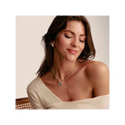 Femme portant un pendentif charm cœur en argent, affichant un style élégant et minimaliste.
