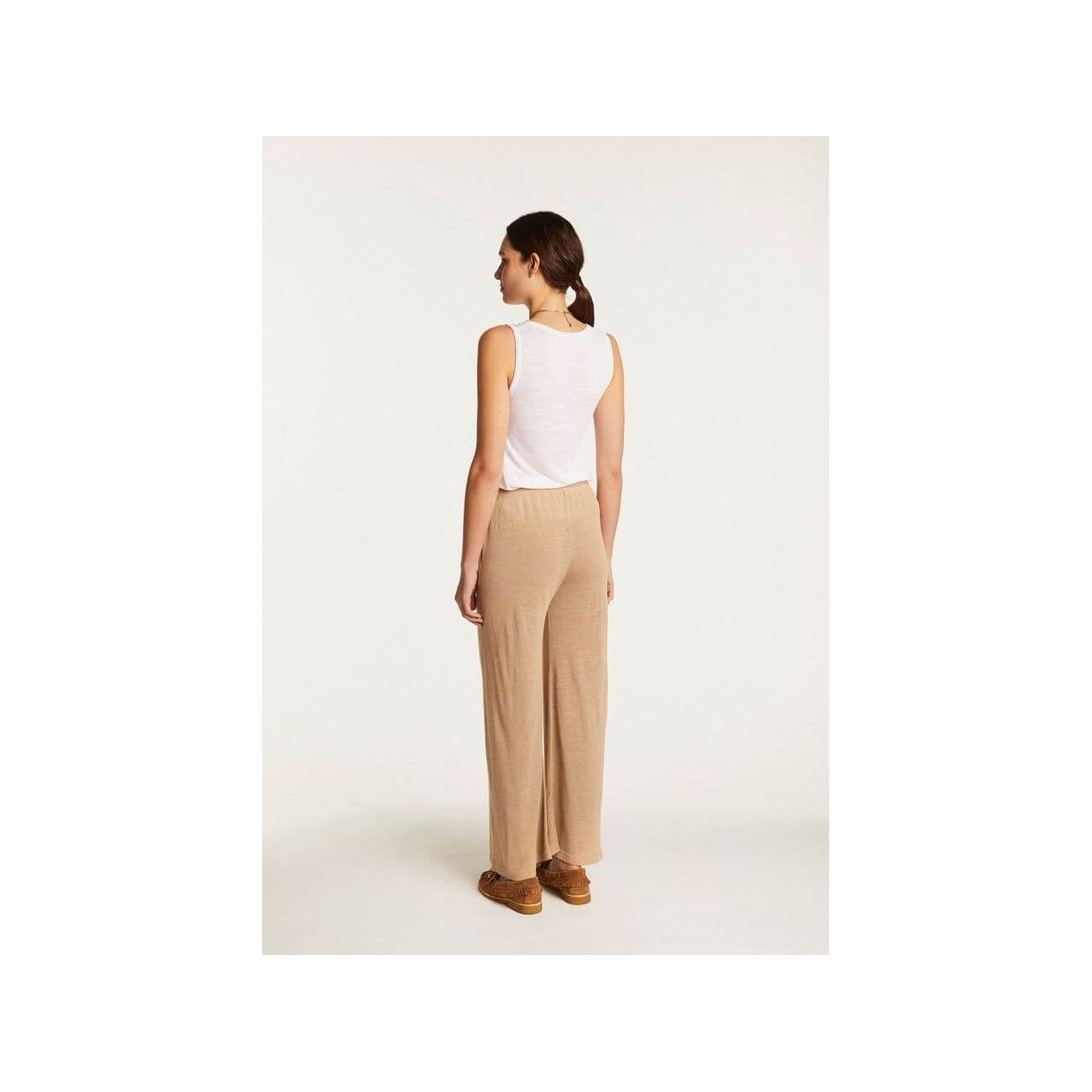 Femme portant le pantalon Debora en lin flammé, vue de dos, style décontracté et élégant, couleur beige.