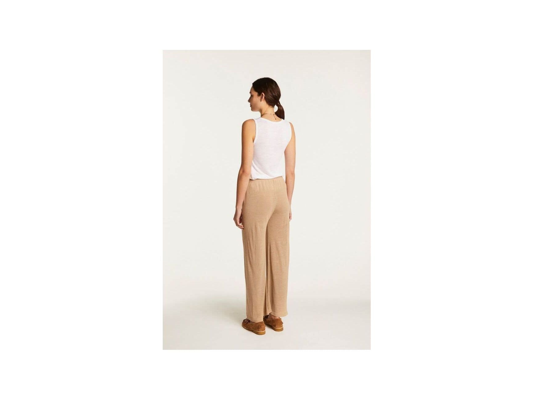Femme portant le pantalon Debora en lin flammé, vue de dos, style décontracté et élégant, couleur beige.