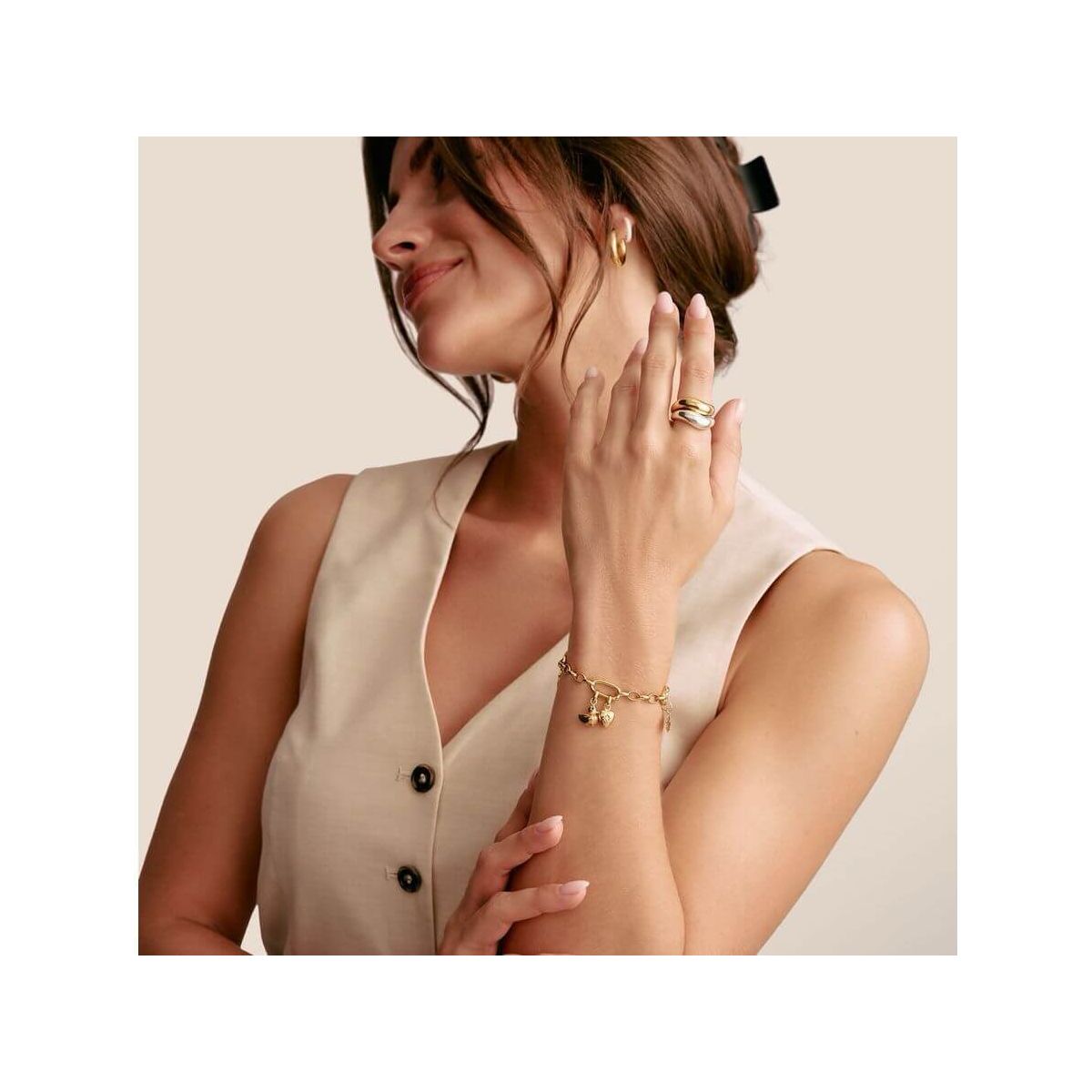 Femme avec pendentif charm canard en plaqué or, portant un bracelet élégant, affichant un style chic.