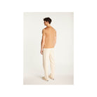 Back view of a man wearing a light brown short-sleeve polo and cream pants, showcasing a stylish and casual outfit.