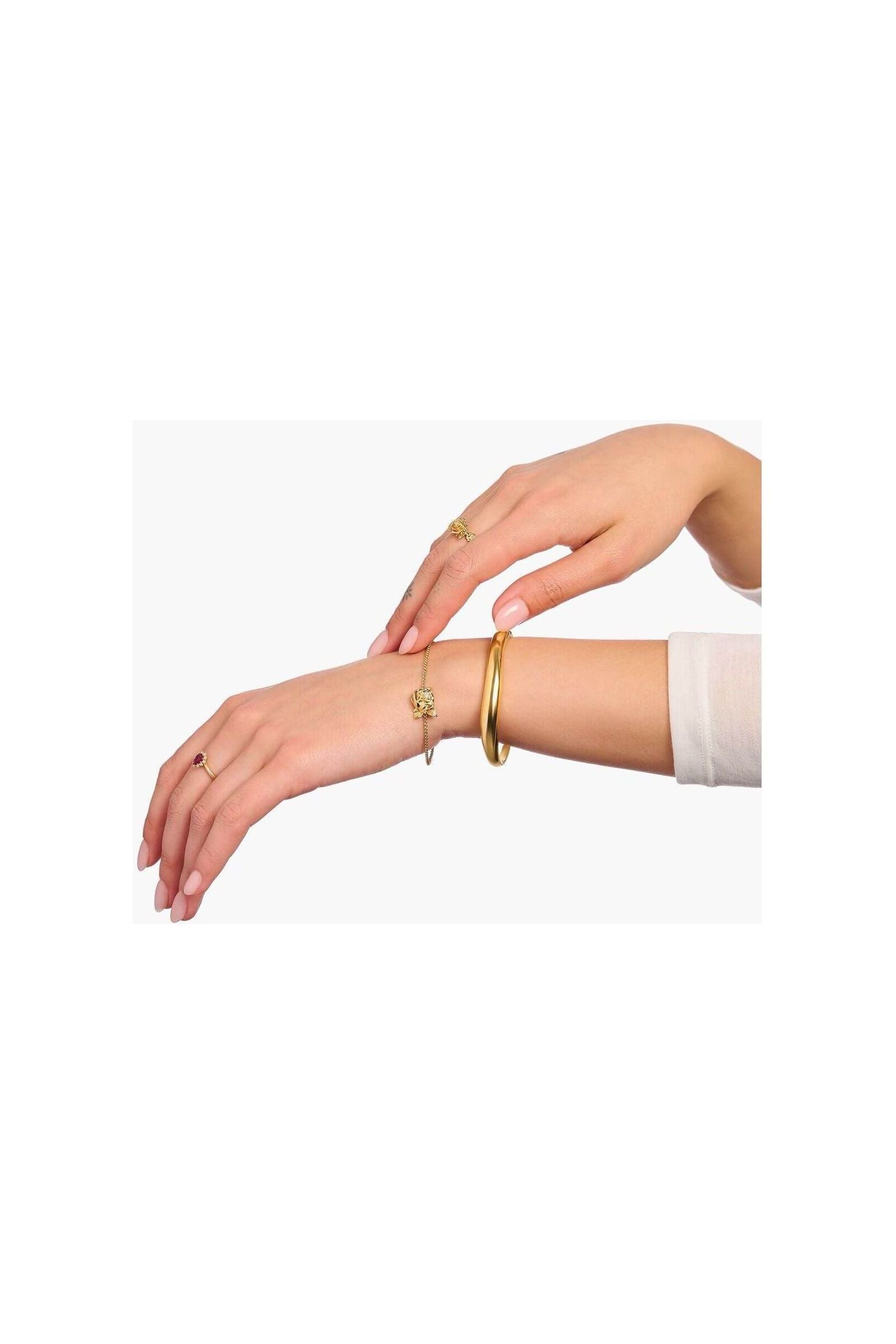 Mainly gold jewelry including rings and bracelets worn on elegant hands for a sophisticated look.