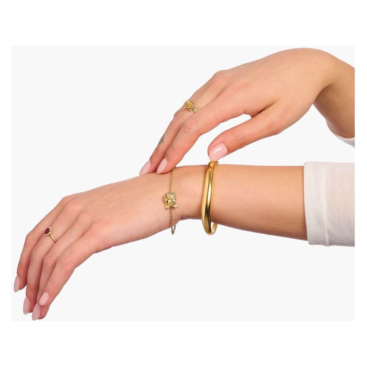 Mainly gold jewelry including rings and bracelets worn on elegant hands for a sophisticated look.