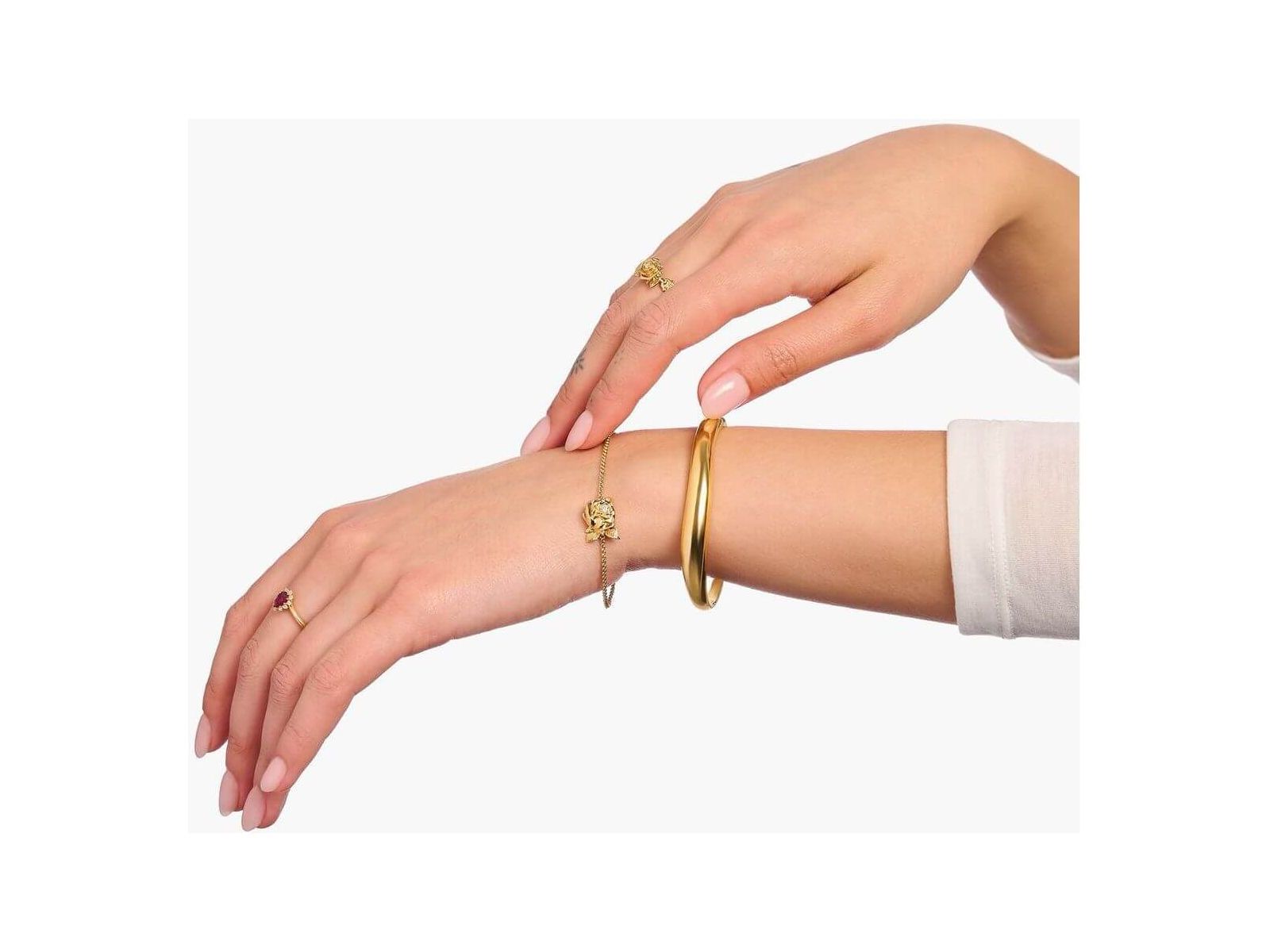 Mainly gold jewelry including rings and bracelets worn on elegant hands for a sophisticated look.