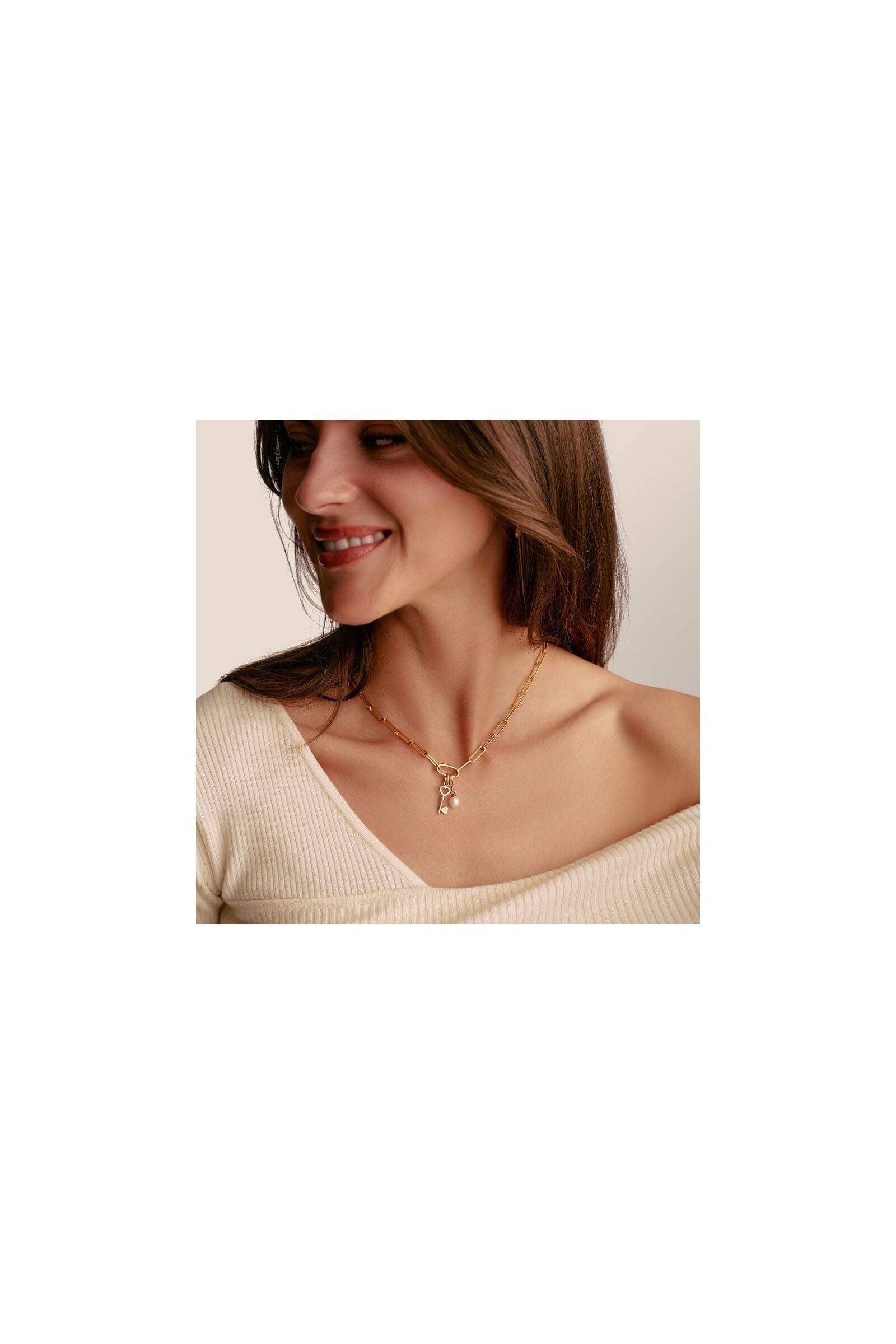 Femme souriante portant le collier Charm Paperclip en or avec Connect Link et breloques, élégant et raffiné.