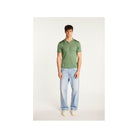 Homme portant un polo fil lumière Babar vert avec jeans clairs, alliant confort et élégance.